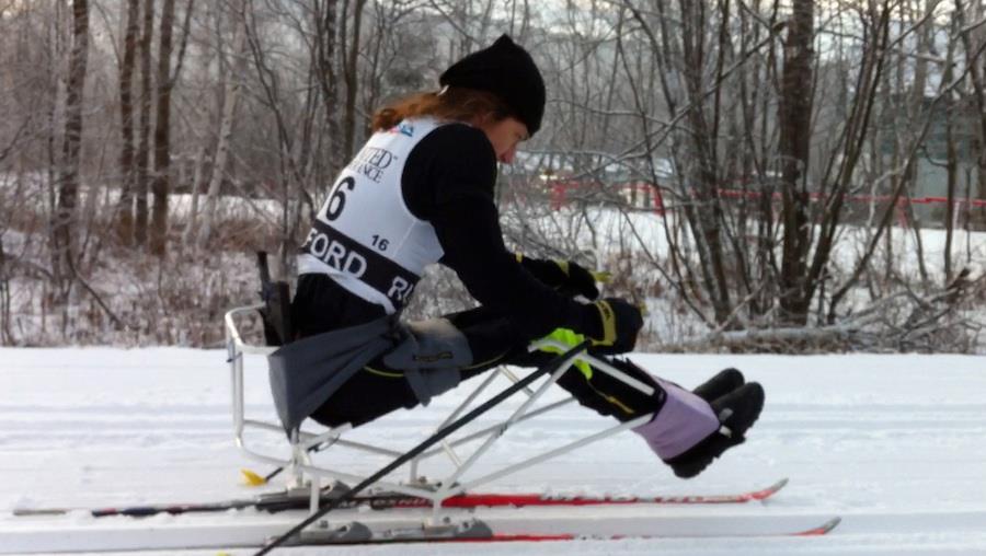 Adaptive ski competitor mid-ski mid-stride