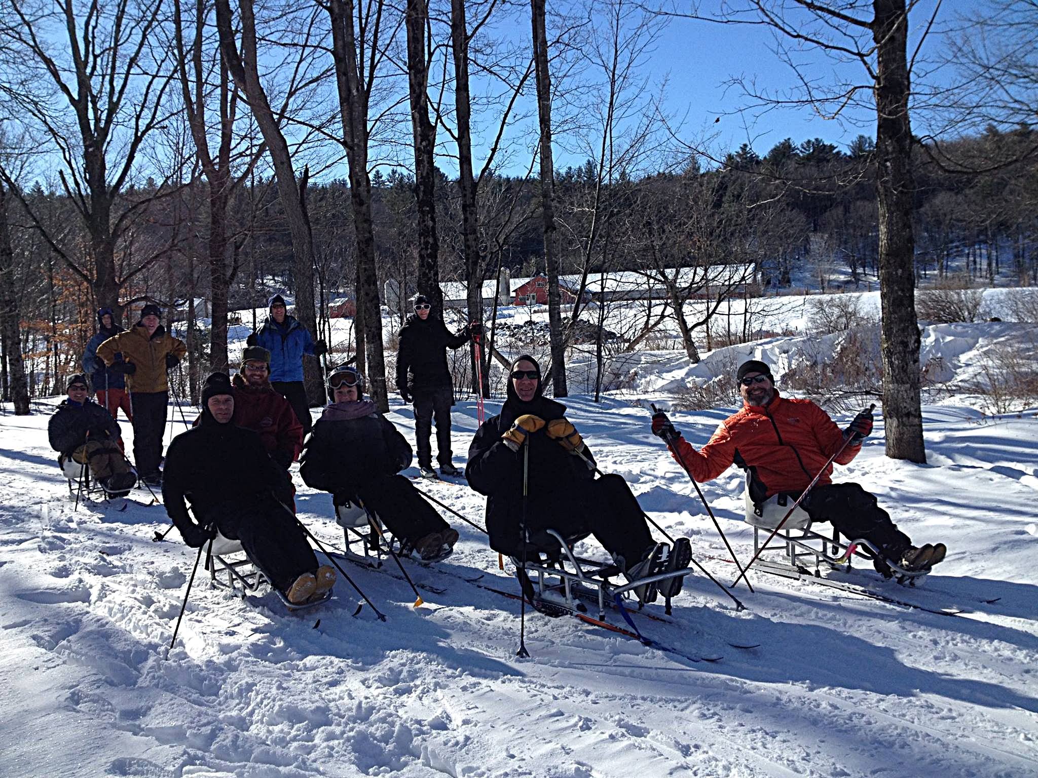 Nordic sit skiiers, including Patrick and Lee, smile on a sunny Vermont winter's day
