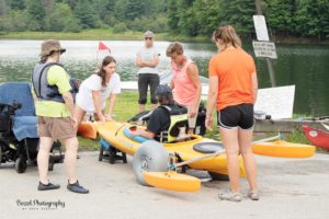 Volunteers launch a kayaker