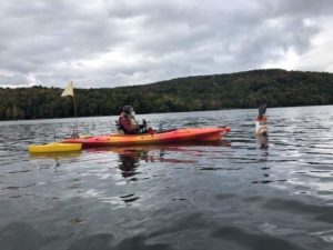 A person wearing a mask kayaks on a Vermont fall day